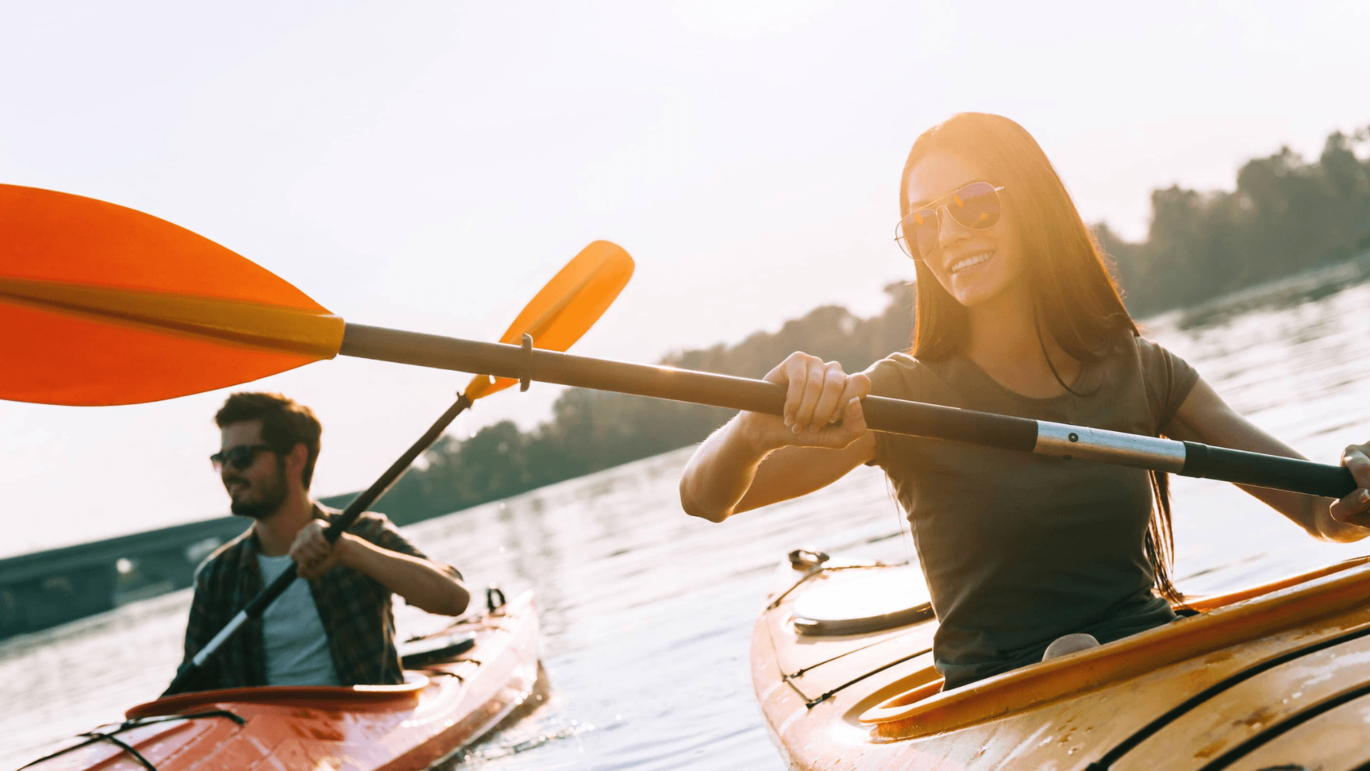 Two individuals kayaking together on a sunny day.
