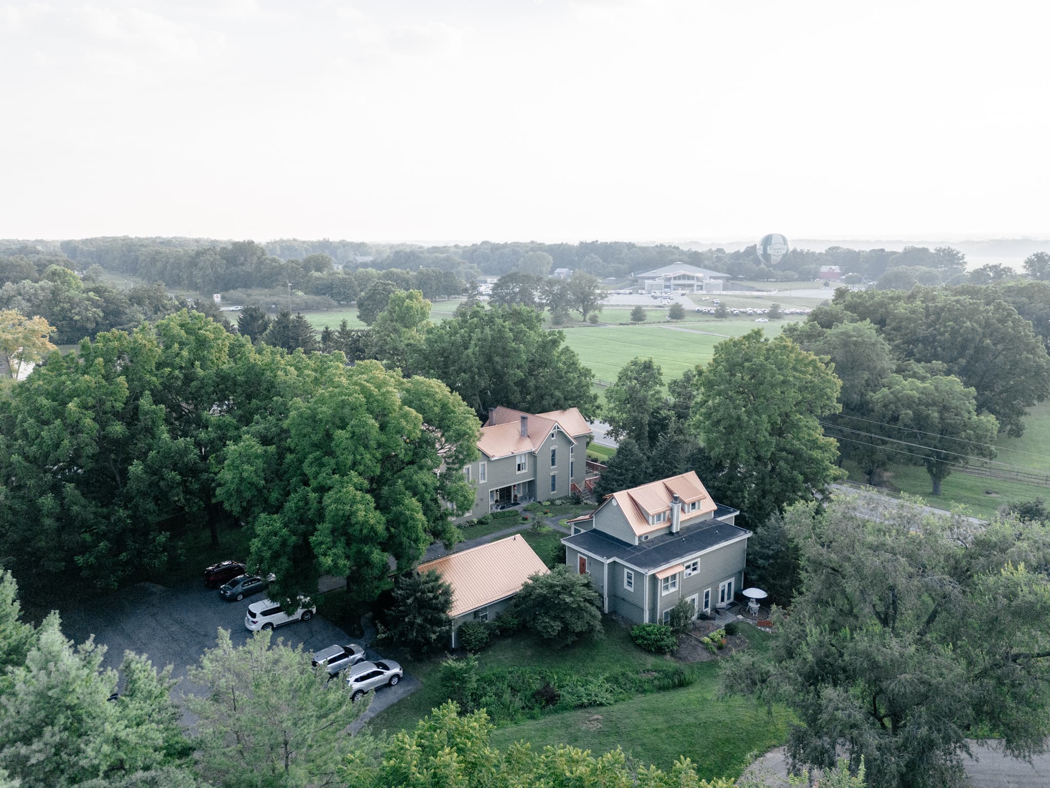 Aerial view of a residential area featuring two houses among lush greenery.