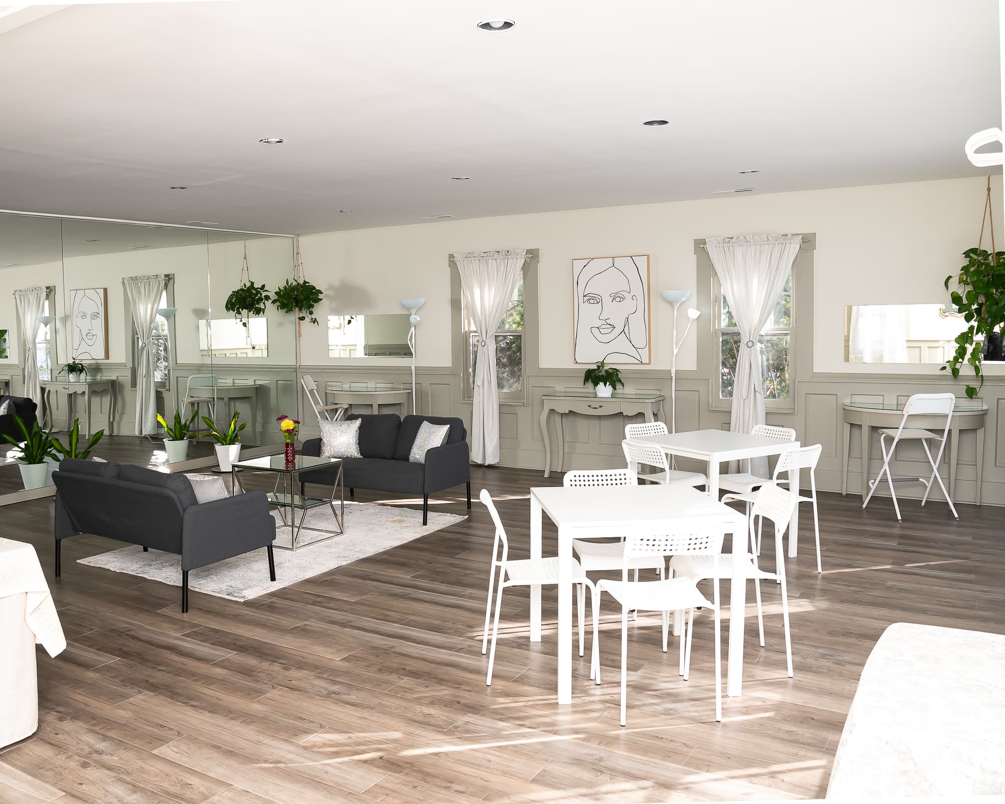 Bright and modern living space with seating, tables, and decorative plants.